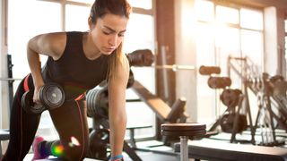 woman working out in gym lifting weights
