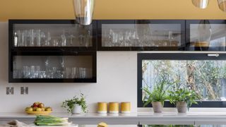 A kitchen with honey yellow accessories and tiles to illustrate the color trends 2023
