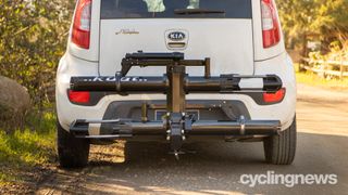 Kuat nv 2.0 2-bike hitch rack fitted to a white KIA car on a sunny day