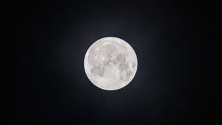 the full moon in a dark sky