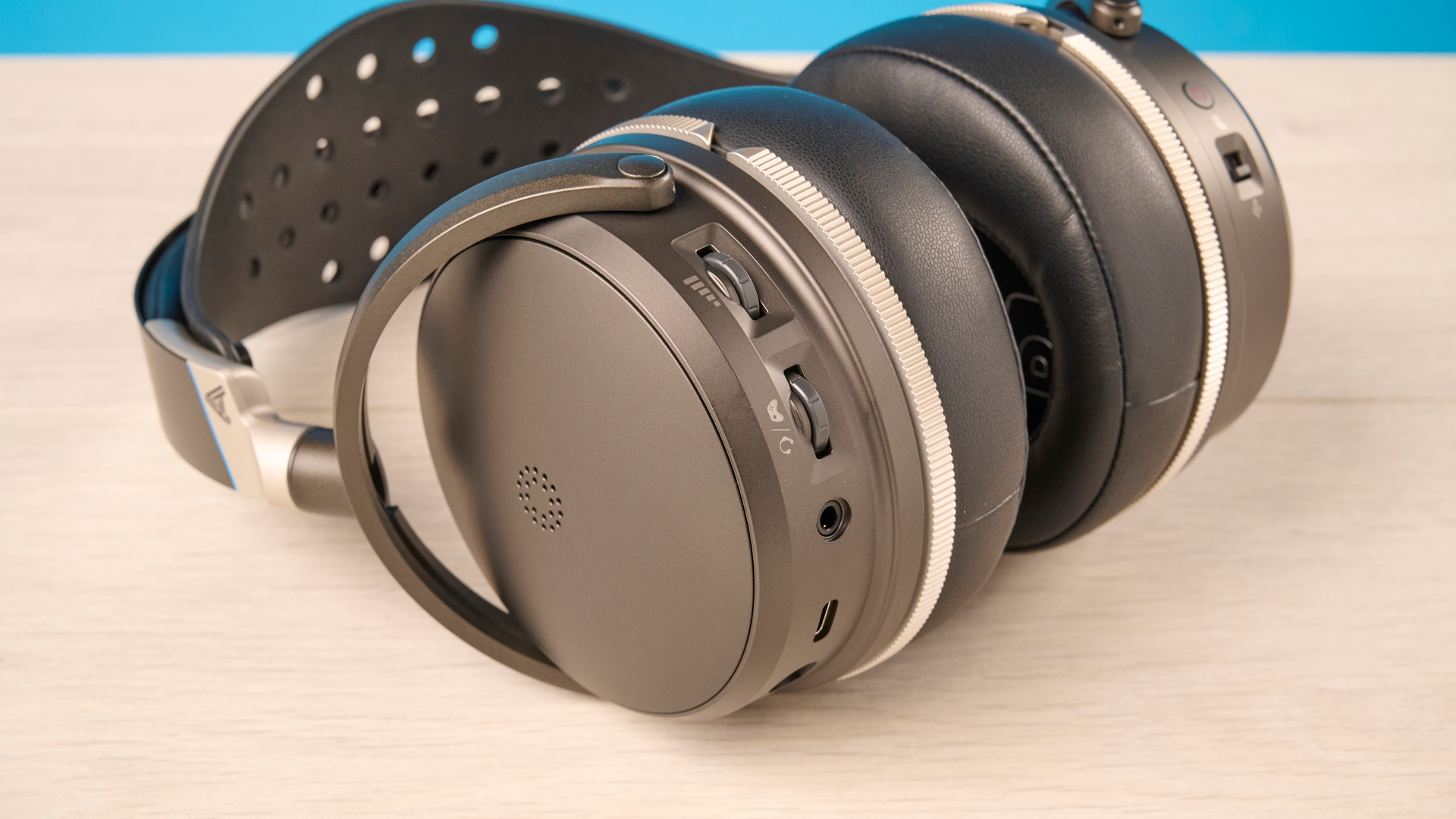 The Audeze Maxwell 2 ANC on a wooden desk with a blue background