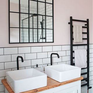 bathroom with light pink wall and white washbasin