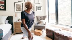 Woman stretching her legs in a bedroom