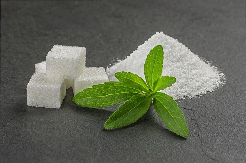 A stevia plant, shown with the sugar substitute made from the leaves.