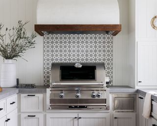 kitchen with light gray cabinets, oven and tiled backsplash