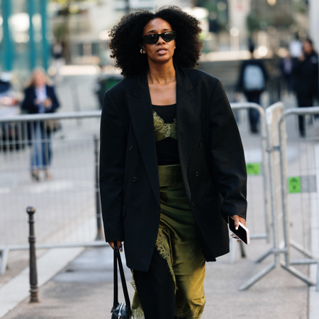 woman wears black blazer green silk dress