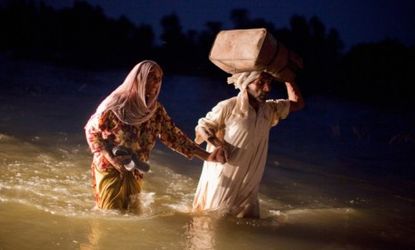 A man and a woman trudge through flood waters on August 22 in Punjab, Pakistan.