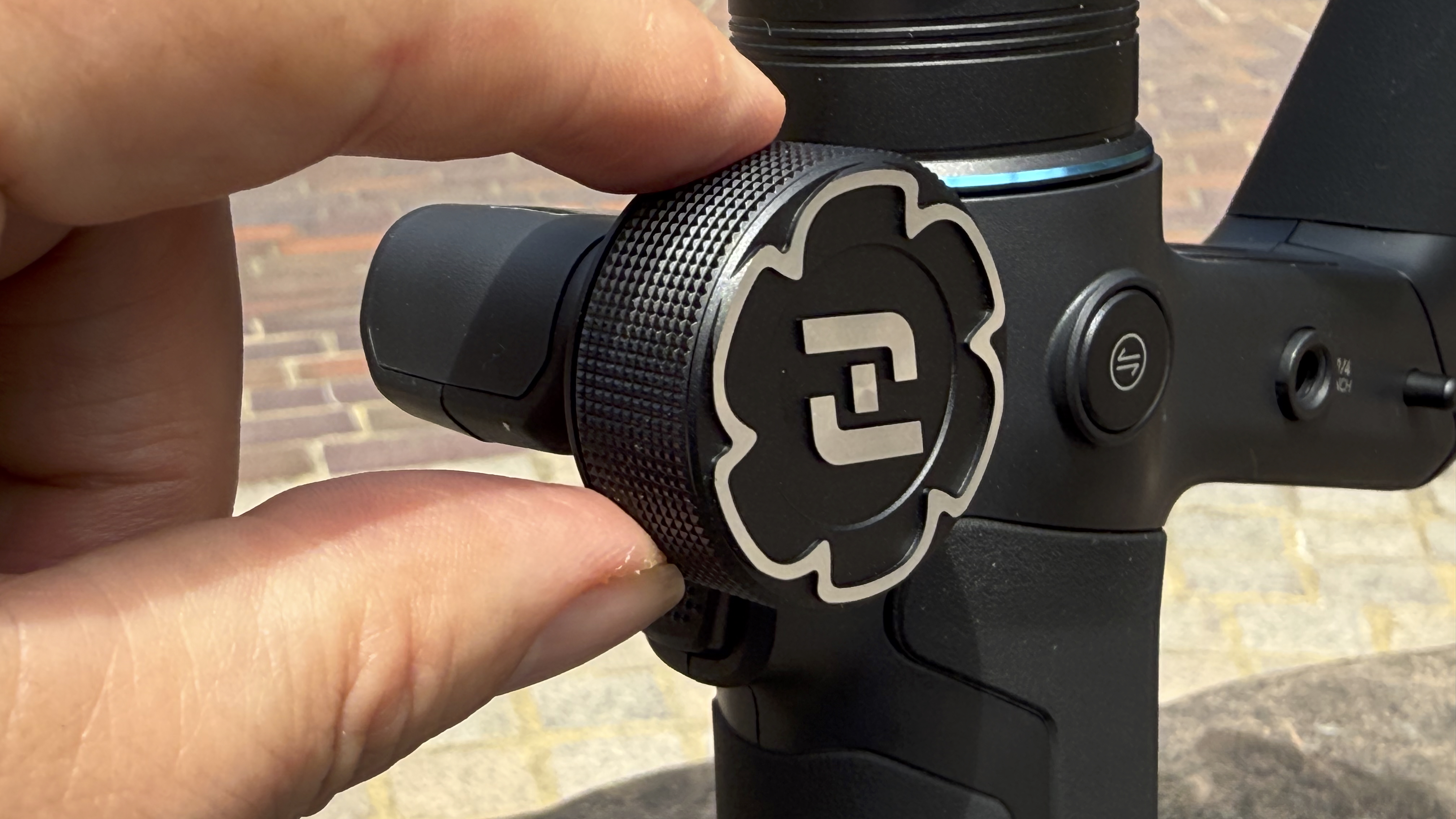 Close-up shot of a hand rotating the large control knob at the front of the gimbal