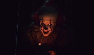 IT Chapter Two Pennywise stands lit by a flame in the darkness