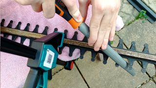 Hedge trimmer blades being sharpened