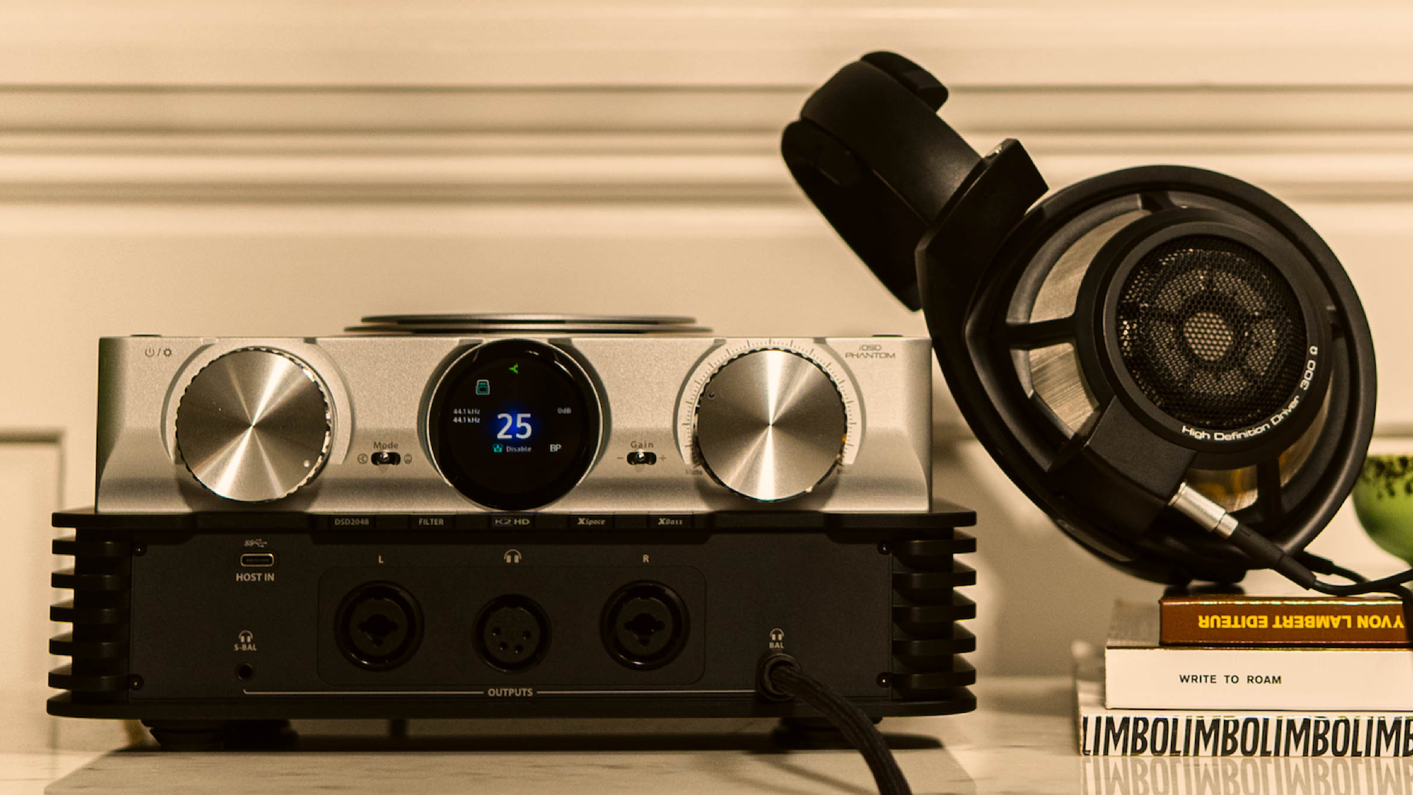 Lifestyle photos of the iFi iDSD Phantom with a pair of open-back headphones next to it