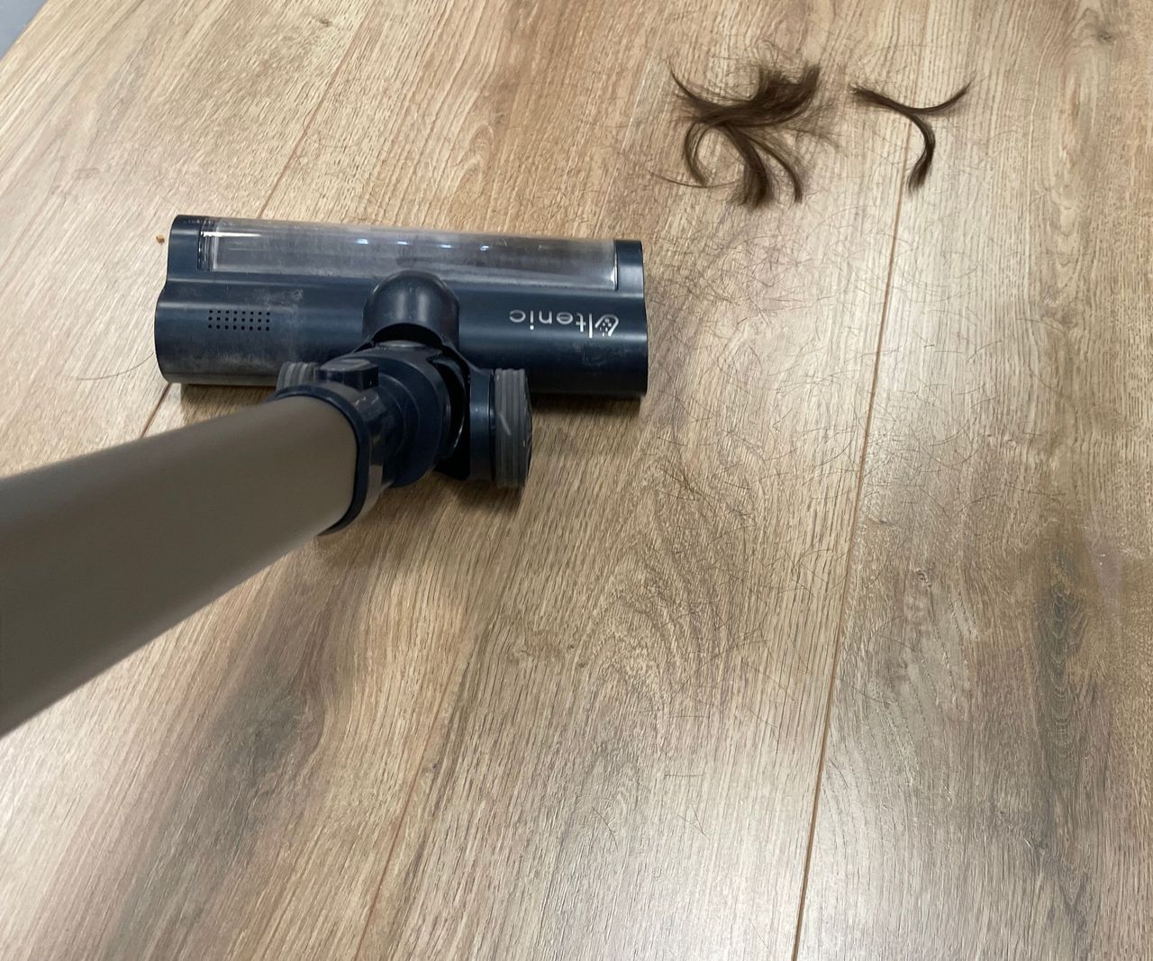 The Ultenic FS1 sucking up hair from a wooden floor