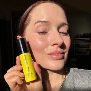 Sofie Pavitt holding a skincare product from Sofie Pavitt Face.