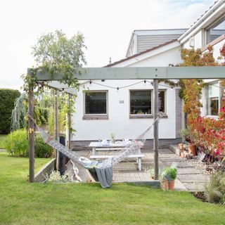 lawn with patio area and hammock in back garden