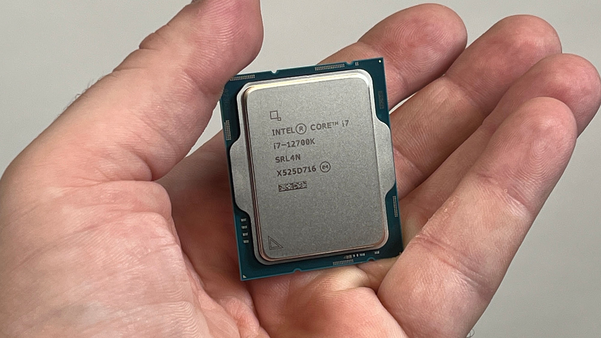 An Intel Core i7-12700K held in a masculine hand