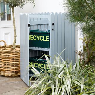 outdoor plants with white box with recycling bin