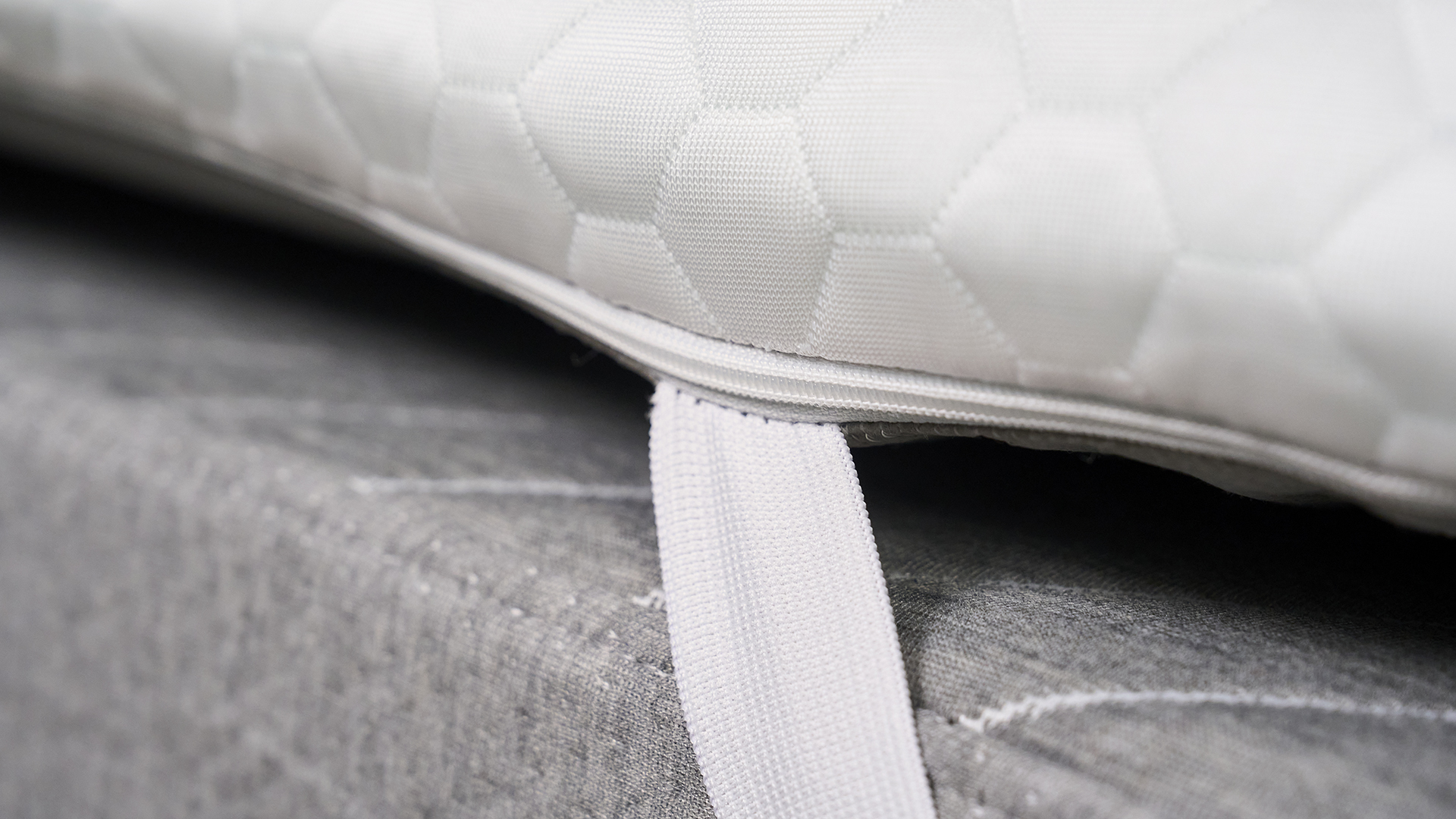 A close-up shot of the elastic anchor straps that are attached to the corner of the Helix Dual Comfort Mattress Topper.