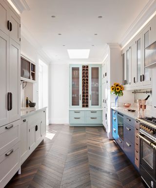 A galley kitchen with a mix of solid and glass fronted cabinets