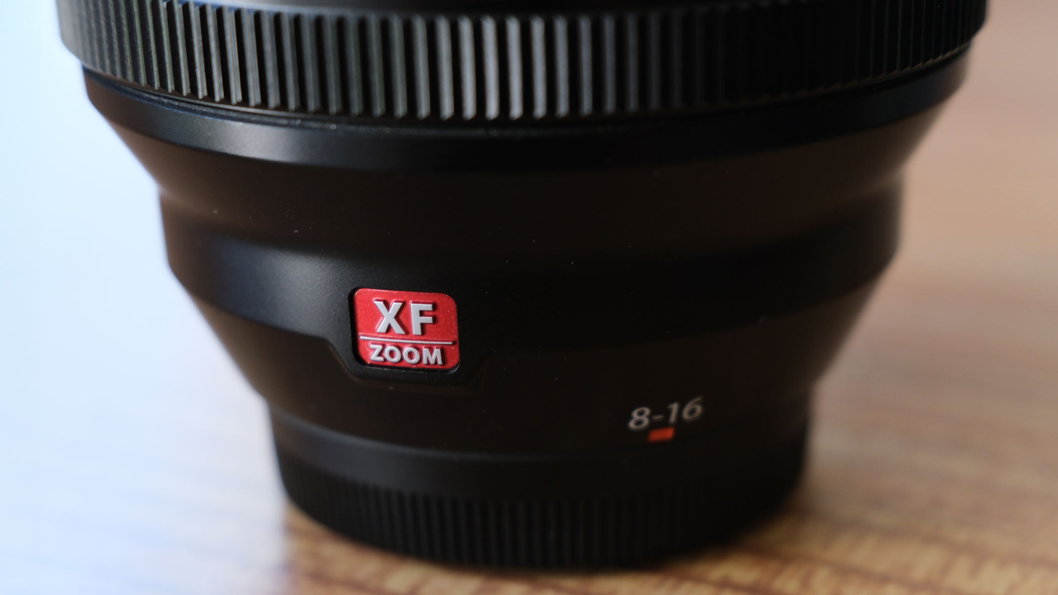 A close-up of the Fujifilm XF 8-16mm f/2.8 lens showing the red XF zoom logo