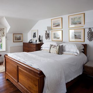 main bedroom with white wall and wooden bed with cosy blanket on bed