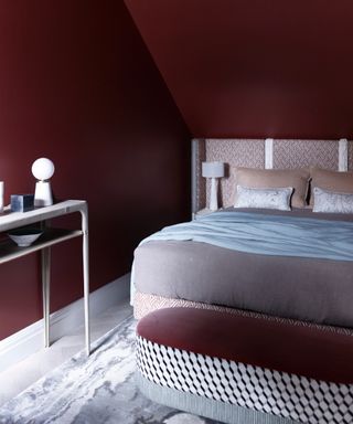 how to make a bedroom darker, loft bedroom, small with magenta coloured walls, upholstered bed, console table, ottoman, oatmeal and beige bedroom, blue throw