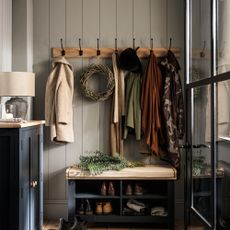 Blue hallway with row of hooks and navy bench