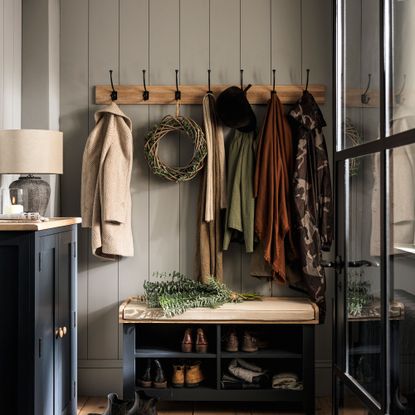 Blue hallway with row of hooks and navy bench