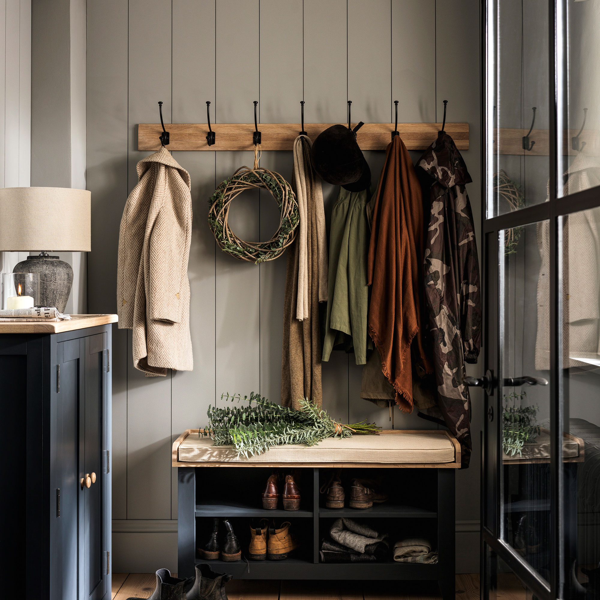 Blue hallway with row of hooks and navy bench