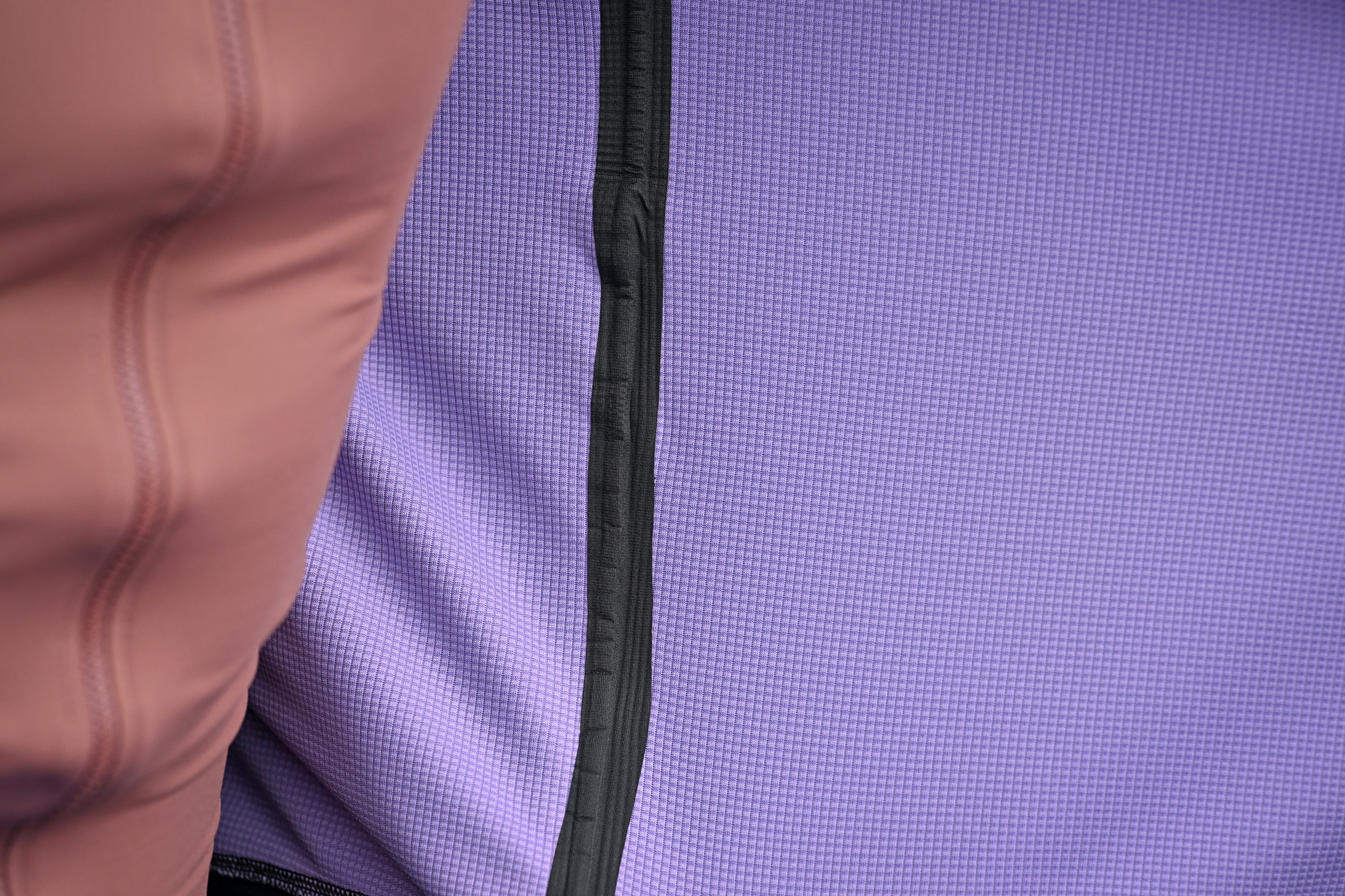 close up of the inside of a purple jacket showing the grid pattern and taped seams
