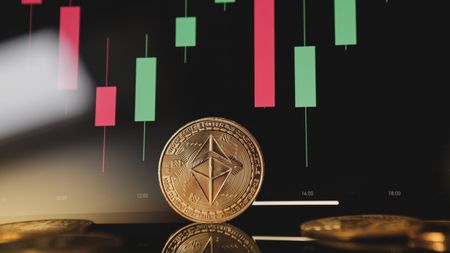 Gold Ethereum crypto currency on background of chart diagram.