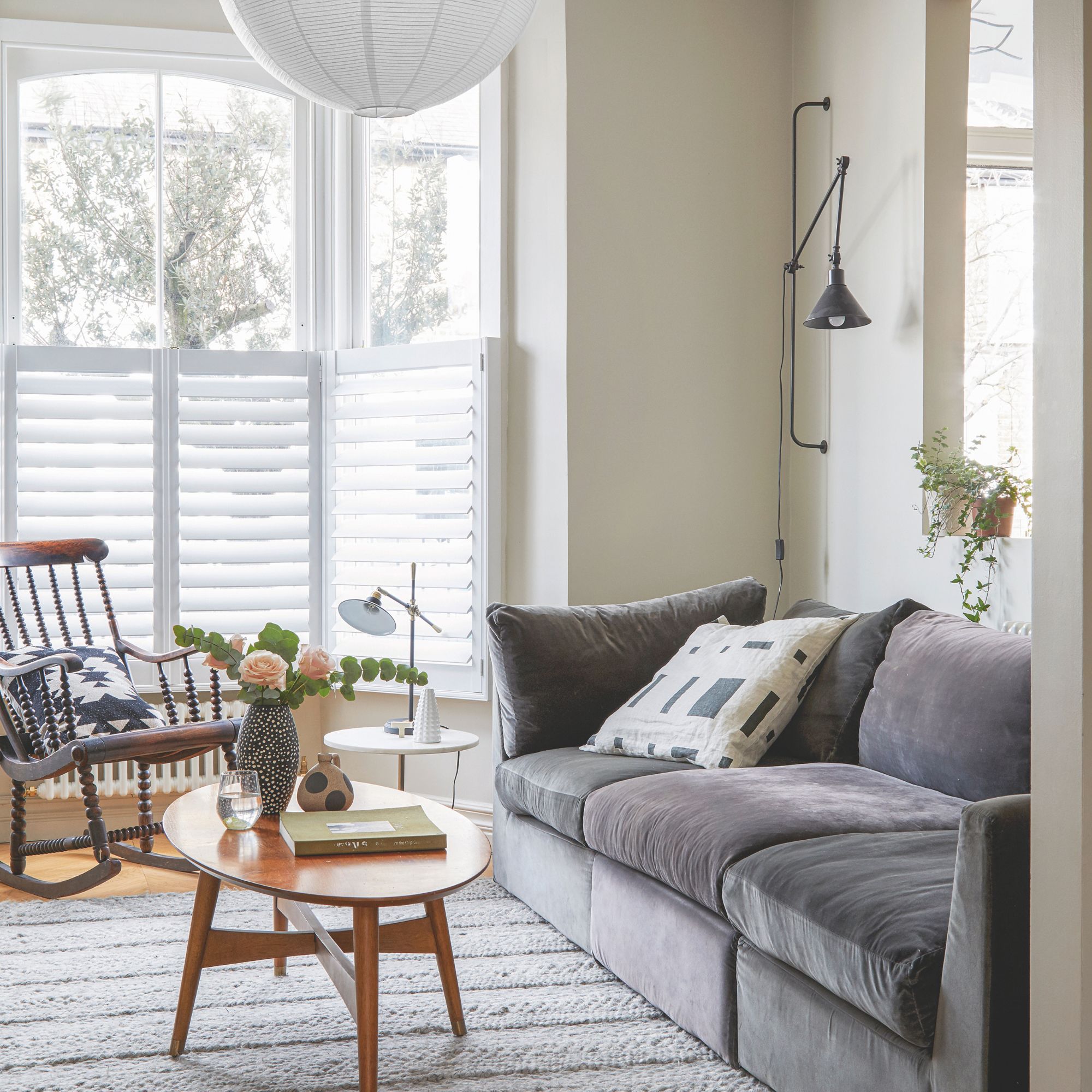 Cream painted living room with a grey sofa and a wooden coffee table on top of a grey rug