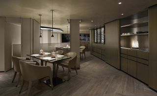 Emporio Armani inner building seating with wooden wall paneling and matching cabinets, low hanging lighting and wooden flooring