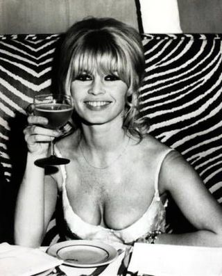 Brigitte Bardot enjoying a glass of wine with lunch