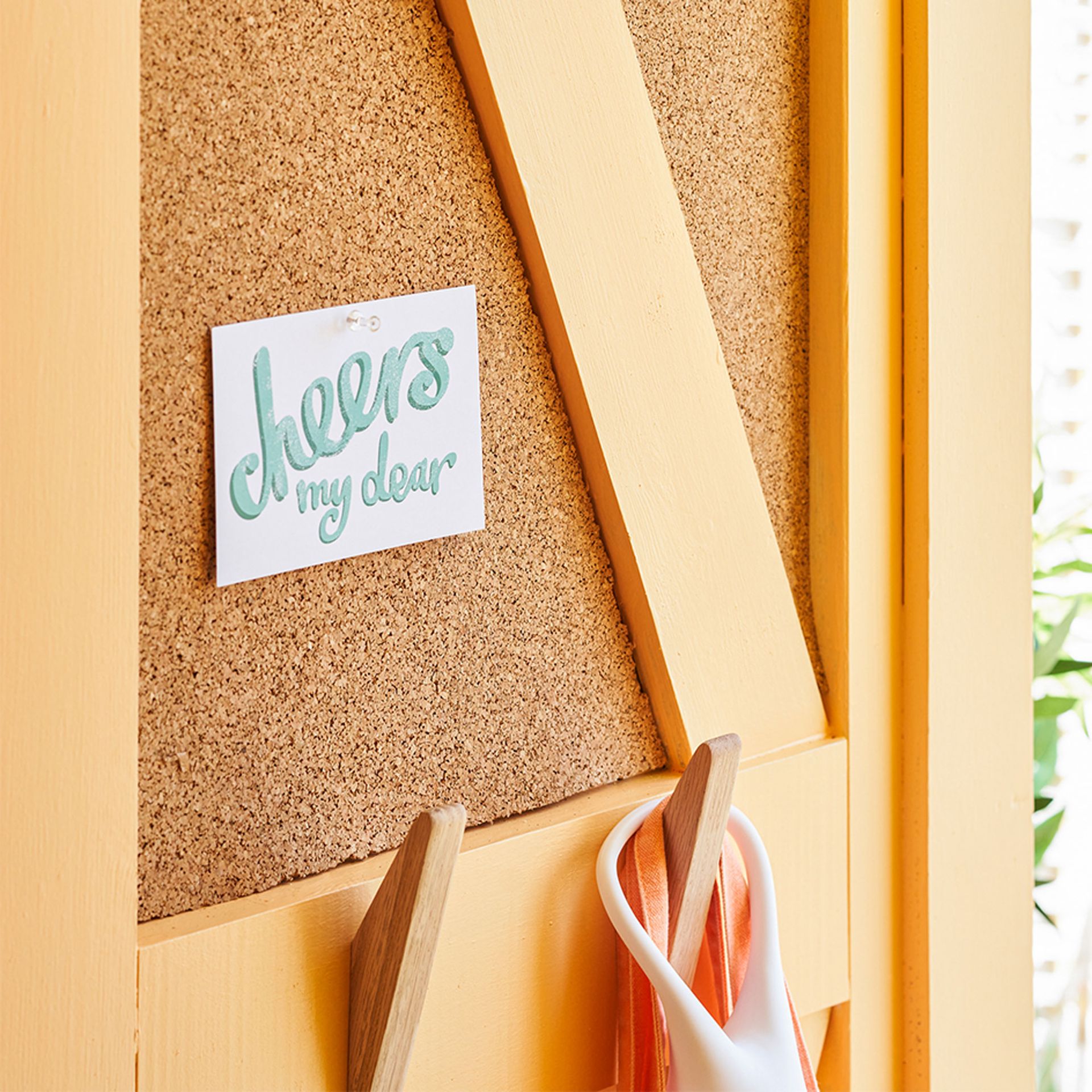 Malowana na pomarańczowo chatka plażowa z korkową tablicą ogłoszeń na drzwiach