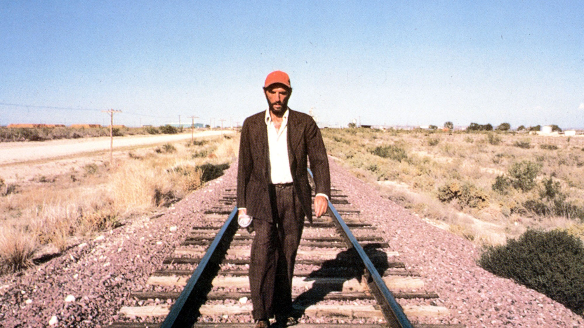 Harry Dean Stanton walking on train tracks in Paris, Texas