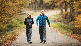 man and woman walking side by side on a woodland path