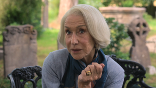 Helen Mirren sitting on a bench in a cemetery in The Thursday Murder Club