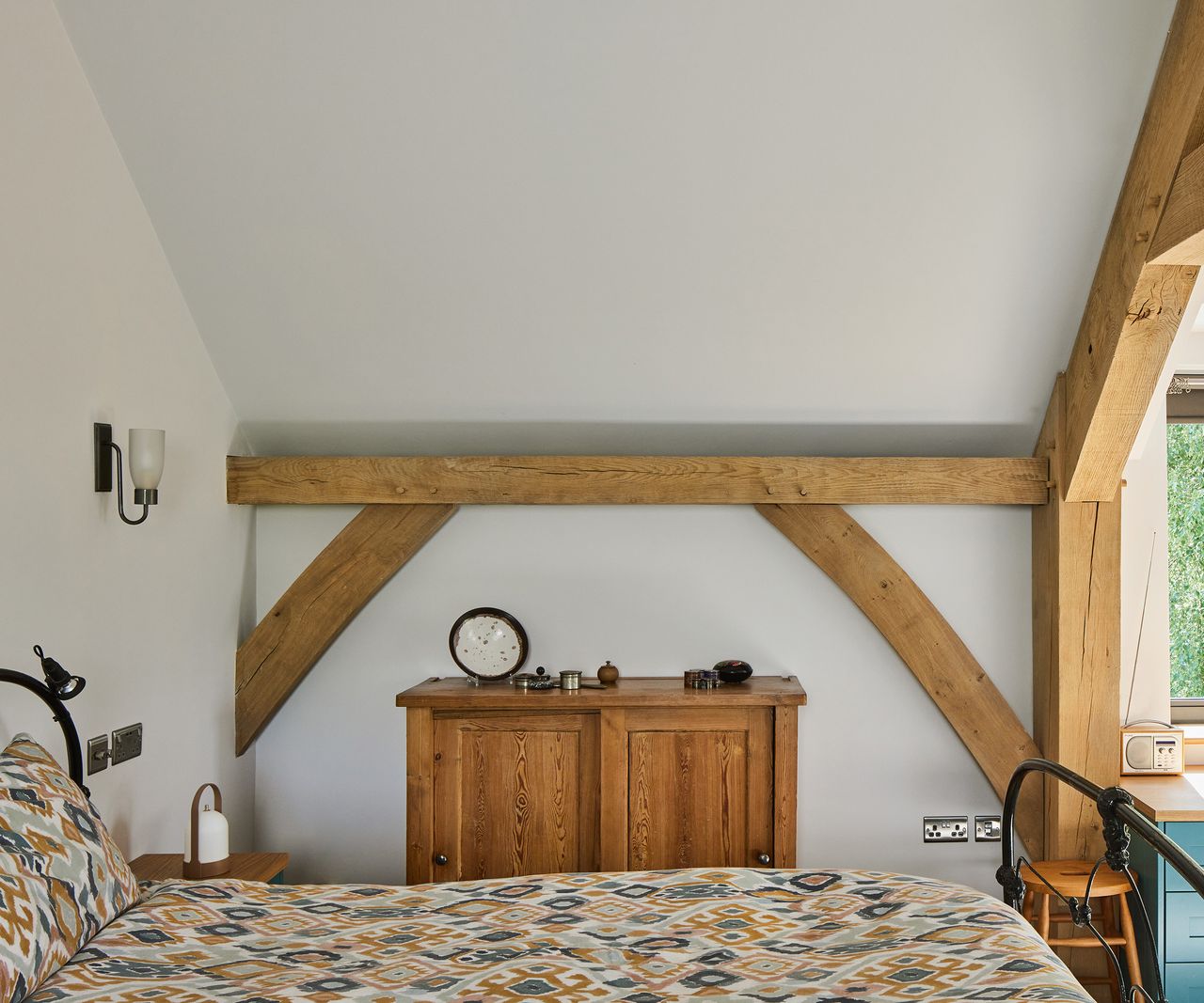 A double bed in a bedroom nook of a seLf build oak frame home. There are some exposed beams