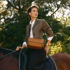 Woman wearing aspinal on a horse