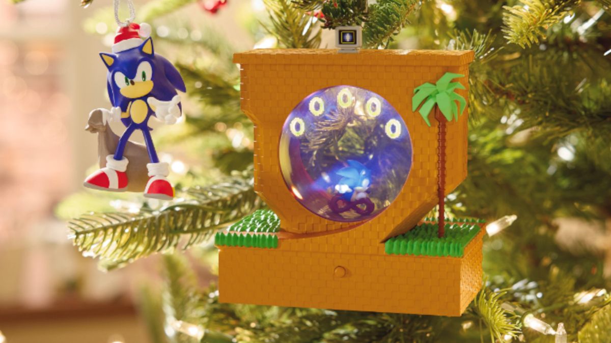 A Sonic ornament wearing a Santa hat hanging from a tree beside a decoration of original Sonic running in Green Hill Zone