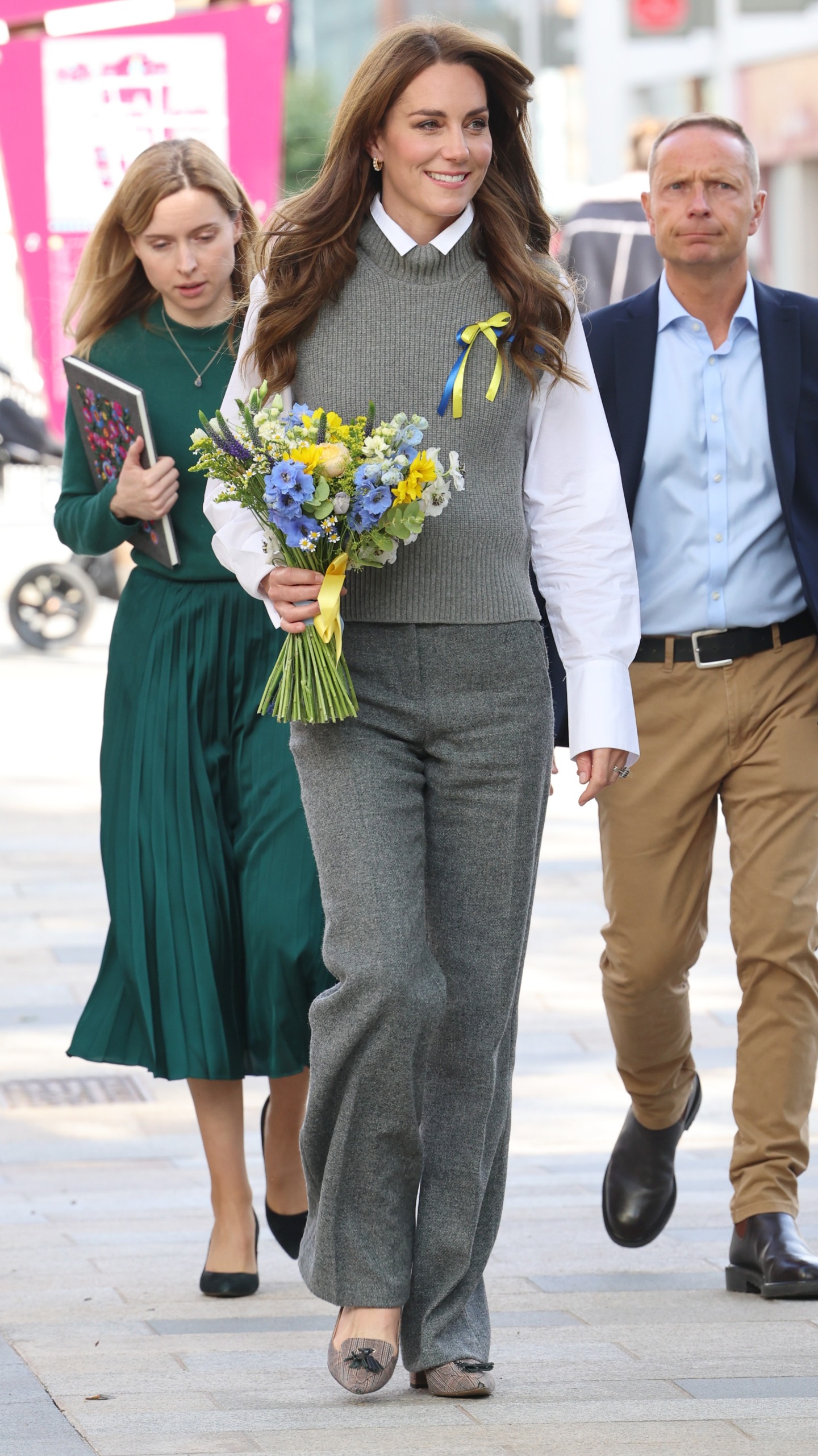 Catherine, Princess of Wales holds a bouquet of flowers and wears a Ukrainian ribbon during her visit to Vsi Razom Community Hub, in the Lexicon Shopping Centre, on October 04, 2023