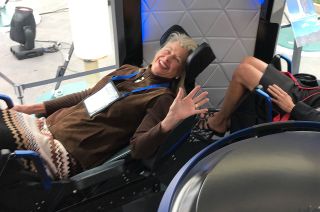 Laura Shepard Churchley, daughter of astronaut Alan Shepard and Blue Origin NS-19 crew member, waves while seated in a mockup of the New Shepard capsule at the Space Symposium in Colorado Springs, Colorado in 2017.