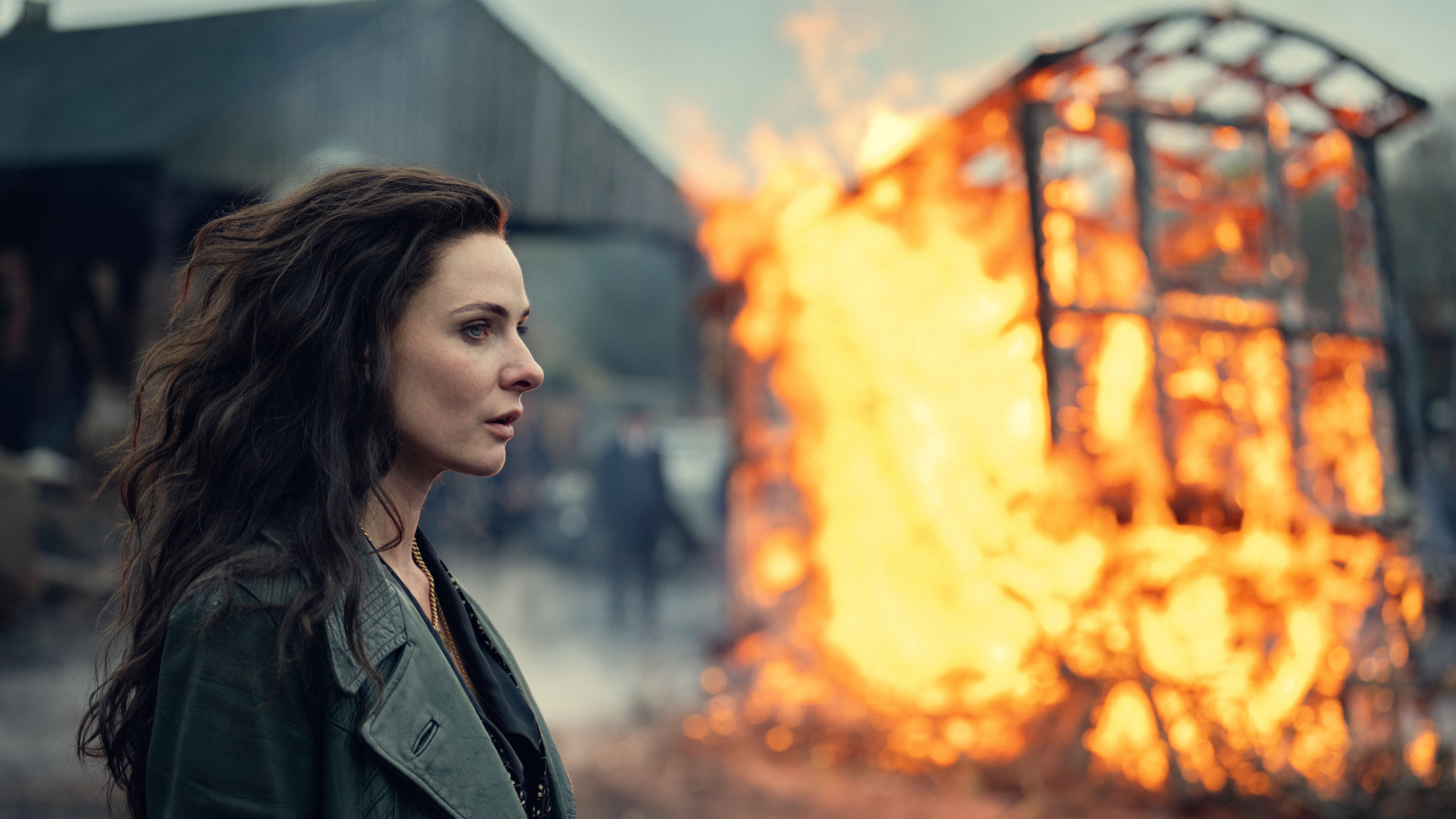 Kaulo (Rebecca Ferguson) stands near a burning carriage in a scene from "Peaky Blinders: The Immortal Man"