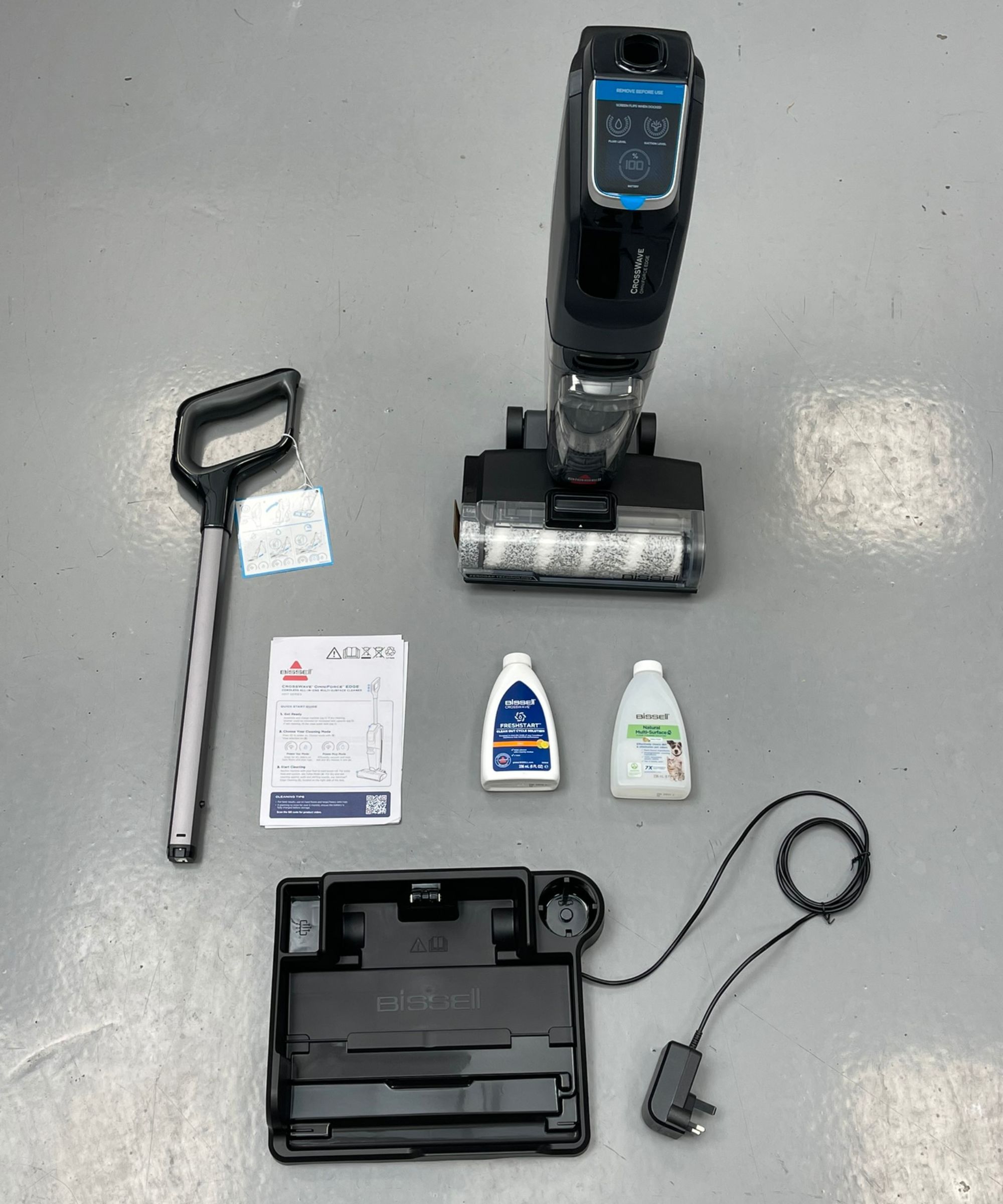 All parts of the Bissell CrossWave OmniForce Edge on gray linoleum floor in Future test center.
