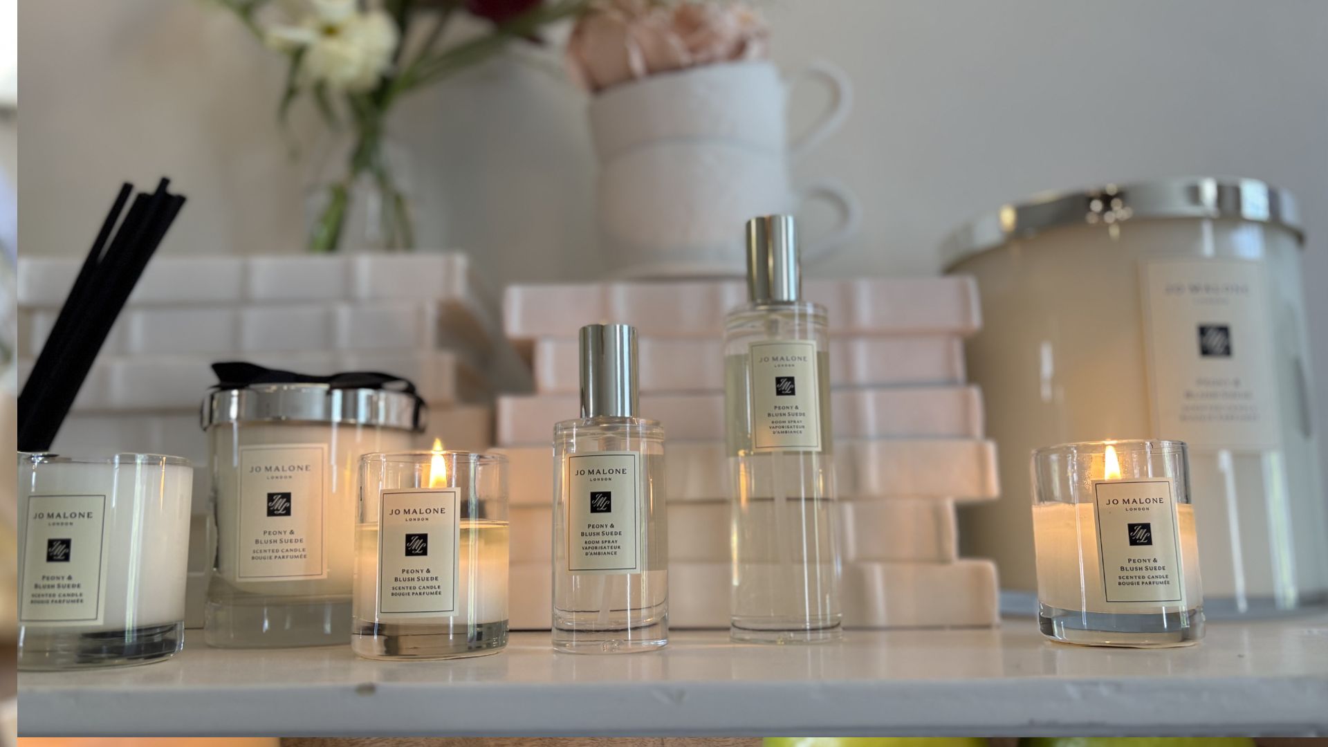 Jo Malone Mini Room Spray next to a full size spray and Jo Malone candles