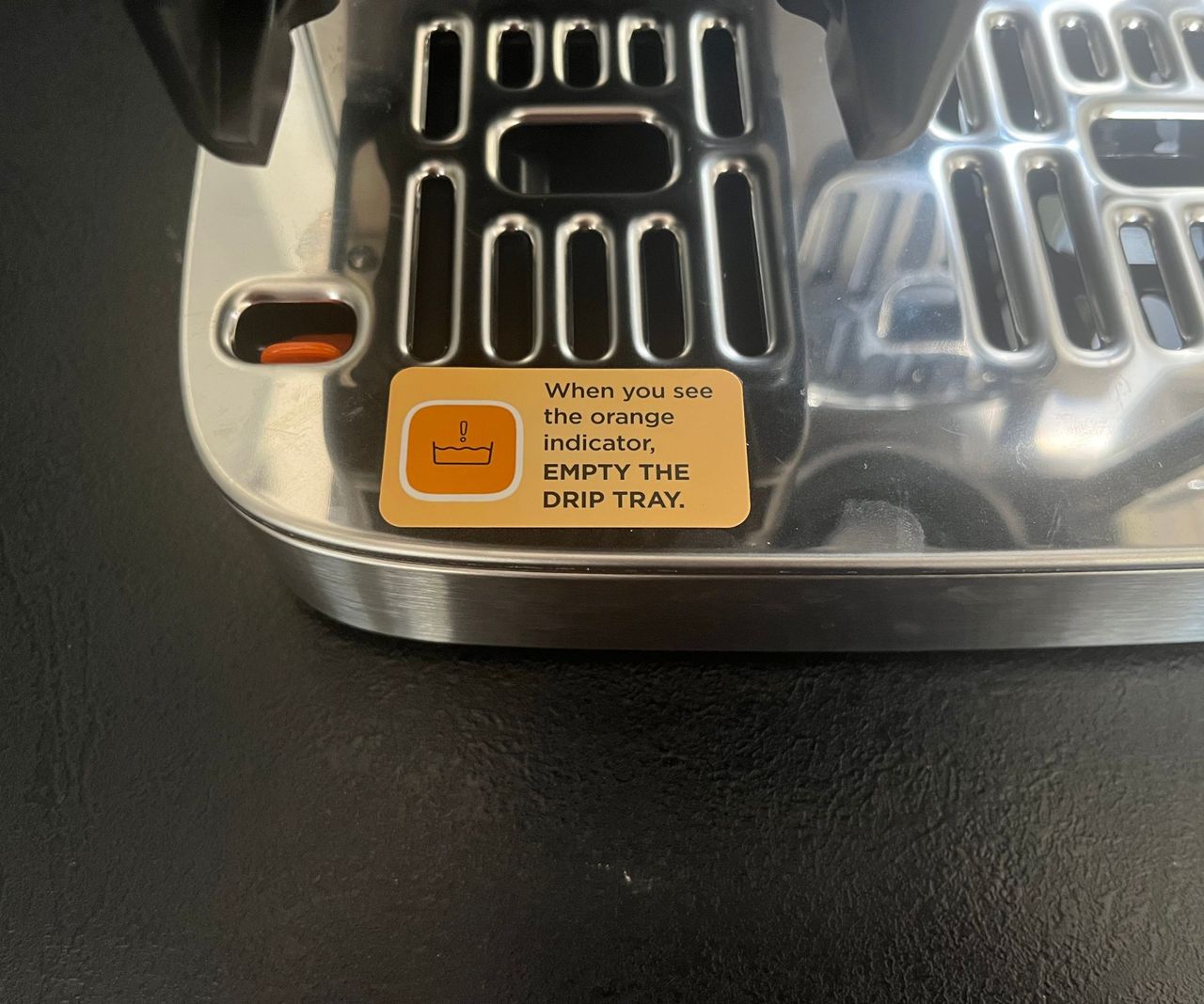 A close up of the sticker explaining the drip tray fullness indicator.