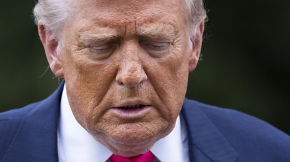 President Donald Trump walks to talk to the members of the media