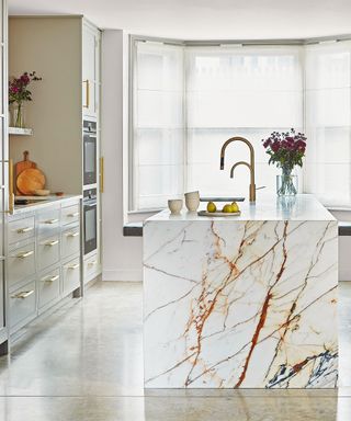 White kitchen with marble island and shaker cabinetry