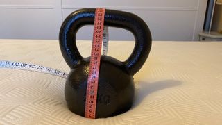A kettlebell and a tape measure on the Panda Hybrid Bamboo mattress