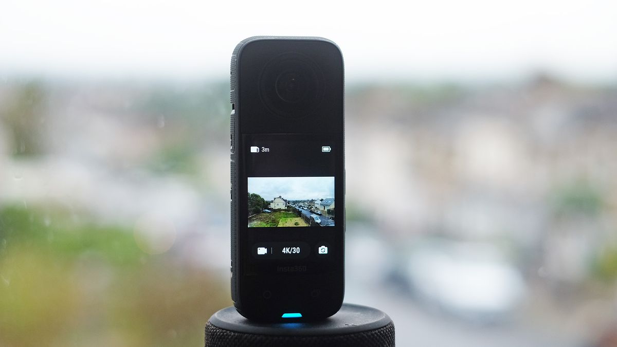 Insta360 X3 on a plynth with blurred cityscape background